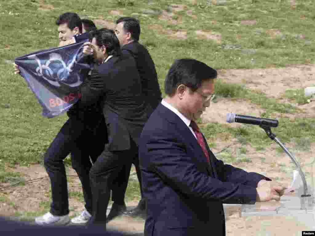 A pro-Tibet demonstrator is arrested during a speech by Chinese Olympic Committee President Liu Qi at the Olympic flame lighting ceremony for the Beijing 2008 Games at the site of ancient Olympia in Greece, March 24, 2008. REUTERS/Mal Langsdon 