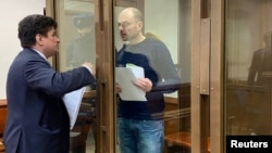 Russian opposition leader Vladimir Kara-Murza (right), talks to his lawyer Vadim Prokhorov during a preliminary court hearing in Moscow on March 6.