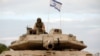 An Israeli soldier sits on top of a tank positioned in the western Galilee area, near Israel's northern border with Lebanon on October 30, 2023, amid the ongoing battles between Israel and the Palestinian group Hamas.