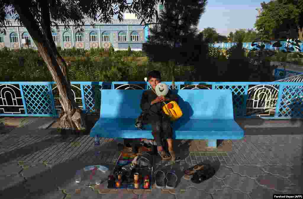 Afghan shoe shiner Qadir, 12, waits for customers along a street in Mazar-e Sharif. (AFP/Farshad Usyan)&nbsp;