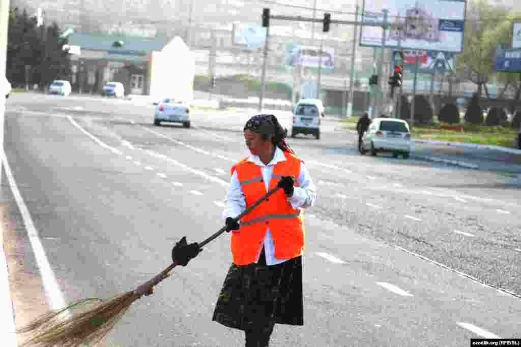 An Uzbek woman cleans the street.