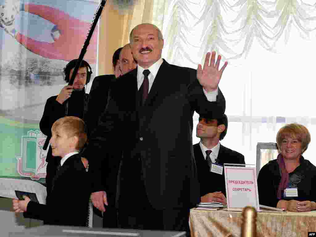 President Alyaksandr Lukashenka waves to journalists as he arrives with his young son to vote in Minsk.