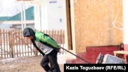 Он жастағы бала су тасып жүр. Алматы облысы, 9 наурыз 2011 жыл.