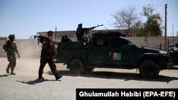 Afghan security officers stand guard outside the residence of Faridoon Momand, an Afghan lawmaker, after a suicide bomb attack in Jalalabad on June 8.