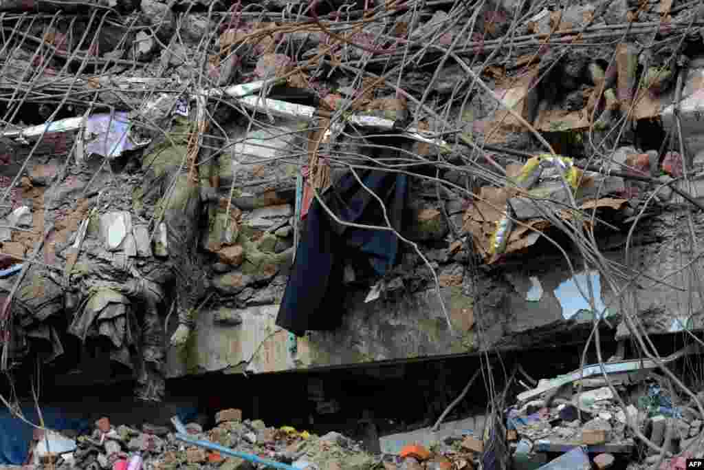 The bodies of Bangladeshi garment workers lie crushed under rubble after an eight-story building collapsed in Savar, on the outskirts of Dhaka. The death toll has passed 500. More than 100 people are still unaccounted for. (AFP/ Munir uz Zaman)