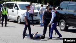 Полицейские задерживают подозреваемого в нападениях на полицейских и здания РУВД и ДКНБ в Алматы. 18 июля 2016 года.