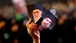 A Hizballah supporter in Beirut holds up portraits of the group's leader Sayyed Hassan Nasrallah and Iranian Supreme Leader Ayatollah Ali Khamenei (file photo)