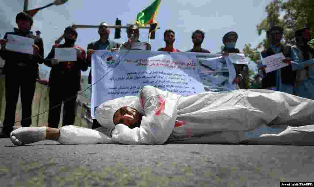 Перформанс в Афганистане: окровавленный мужчина лежит на дороге. Рядом протестующие выкрикивают антииранские лозунги. Во время акции у посольства Ирана в Кабуле (Epa-EFE / Jawad Jalali)