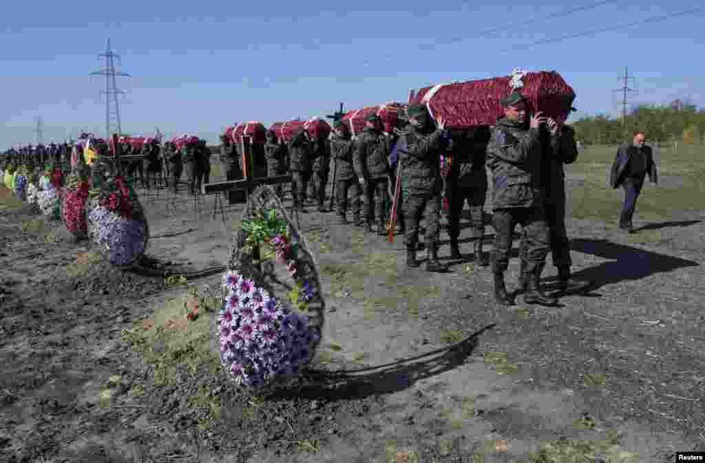 Members of the Ukrainian National Guard carry coffins as they attend a mass funeral ceremony at a cemetery in Dnipropetro to bury unidentified soldiers of pro-Ukrainian military forces who were killed while taking part in the conflict in the country's east. (Reuters/Sergei Isaev)