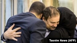 Iranian doctor Majid Taheri, who had been detained in the United States for 16 months, hugs his children upon his arrival at Tehran's Imam Khomeini International Airport on June 8, 2020.