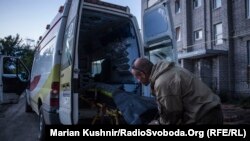 Водій з екіпажу медиків-добровольців витягує ноші з реанімобіля