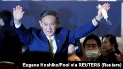 Szuga Josihide ünnepel, amikor a Liberális Demokrata Párt jelentős többséggel választotta meg vezetőnek