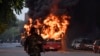 A man walks on a street as a bus is on fire following a demonstration against the Indian government's Citizenship Amendment Bill (CAB) in New Delhi on December 15.