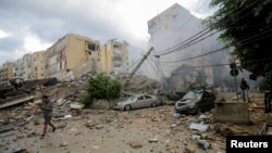 A man walks near damaged buildings in the aftermath of Israeli strikes on Beirut's southern suburbs on October 1.