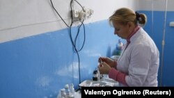 Egy oltást készít elő betegének az orvos az ukrajnai Sztajki klinikáján, 2015. november 11.