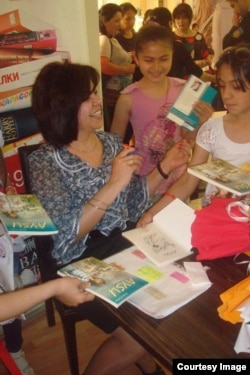 Rehan Yusifqızı Şıxlınskaya uşaqlar üçün öz kitabını imzalayır.
