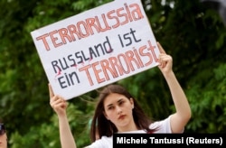 Участница акции протеста с лозунгом "Россия – государство-террорист" близ штаб-квартиры Канцлера Германии. Берлин, 8 июля 2022 года