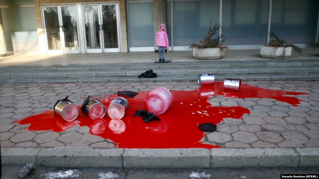 Детски манекен на фона на червената боя. Входът на заден план води към посолството на Руската федерация в София.