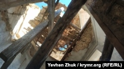 Сквозь разрушенный потолок и висящие балки видно небо