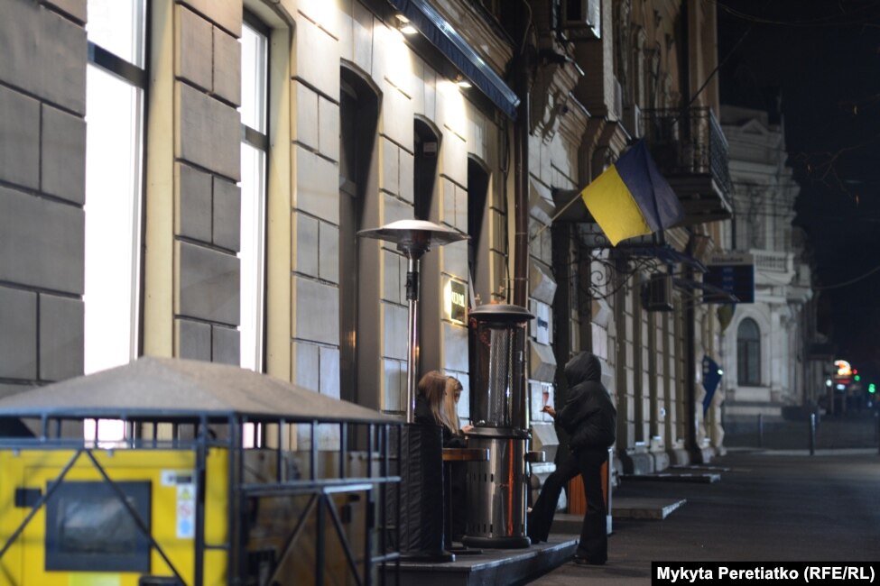 Women stand outside a restaurant in central Dnipro on December 11.