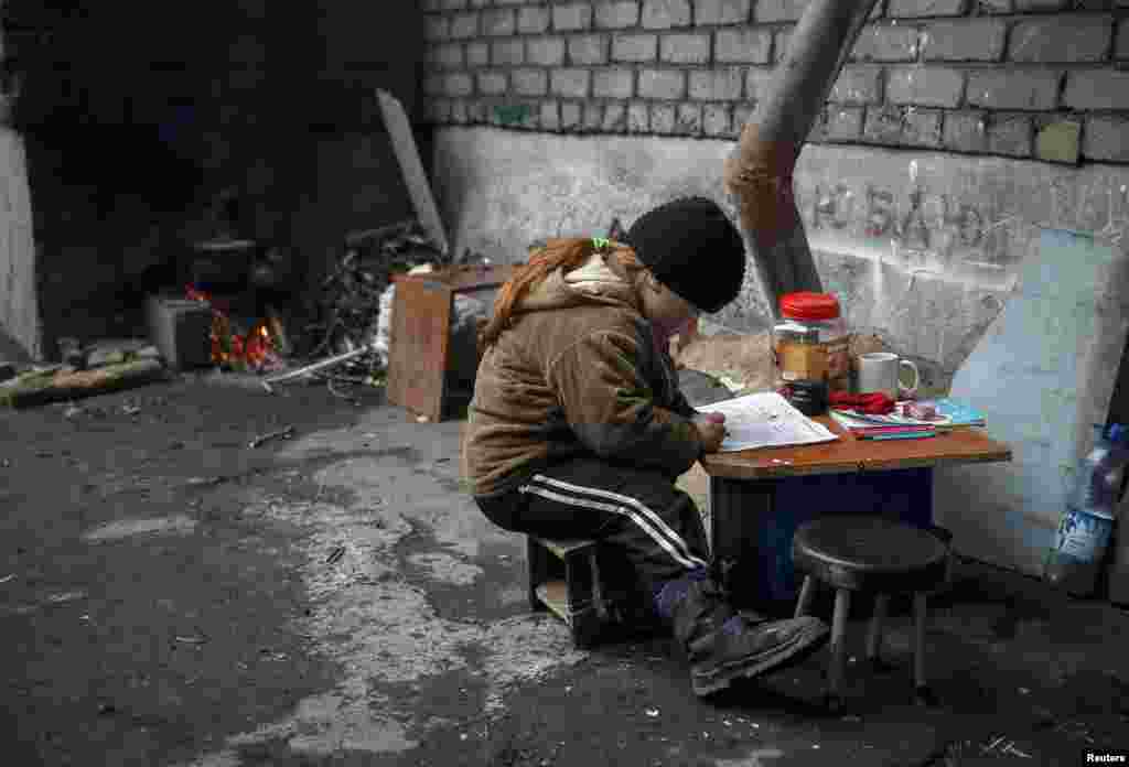 A child draws near her house in the eastern town of Debaltseve, Ukraine, which has been the scene of heavy fighting for several weeks, with separatists pushing forward with an offensive they say is aimed at controlling the entire Donetsk region. (Reuters/Gleb Garanich)