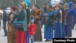 Туркманистонлик айллар бекатда автобус кутмоқда.