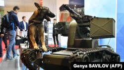 Поліцейський пес стоїть біля українського бойового робота на Міжнародній спеціалізованій виставці «Зброя та безпека-2018». Київ, 10 жовтня 2018 року