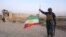 A member of Iraqi federal forces holds the Kurdish flag upside down in Kirkuk on October 16.