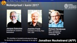 A screen displays portraits of winners of the 2017 Nobel Prize in chemistry, Jacques Dubochet (left to right), Joachim Frank, and Richard Henderson, at the Royal Swedish Academy of Sciences in Stockholm on October 4.