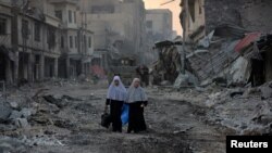 خاوند: ستون فقرات اقتصاد «داعش» با آزادی موصل در هم شکسته شده است. دو شهروند عراقی در شهر قدیمی موصل،چهارم ژوئیه ۲۰۱۷ 