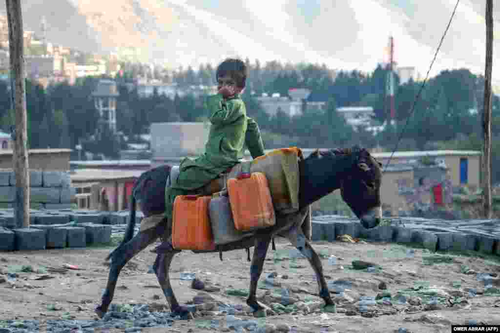 An Afghan boy rides a donkey along a road in the Fayzabad district of Badakhshan Province.