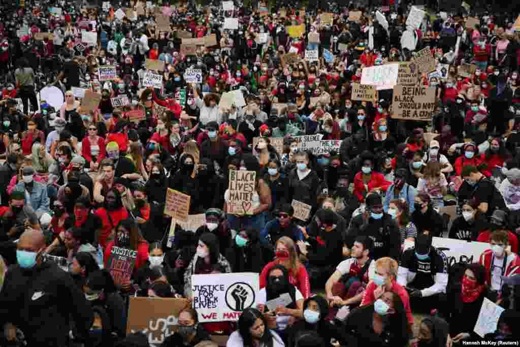 Люди в захисних масках проти коронавірусу тримають в руках плакати під час акції протесту у Лондоні, Велика Британія, 3 червня 2020 року (Фото REUTERS/Hannah McKay)