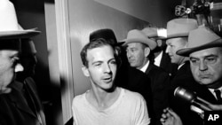 23 лістапада 1963 году. Лі Гарві Освальд пасьля затрыманьня пасьля забойства прэзыдэнта ЗША. 
