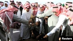 Mourners bury the body of Saudi King Abdullah during his funeral in Riyadh on January 23.