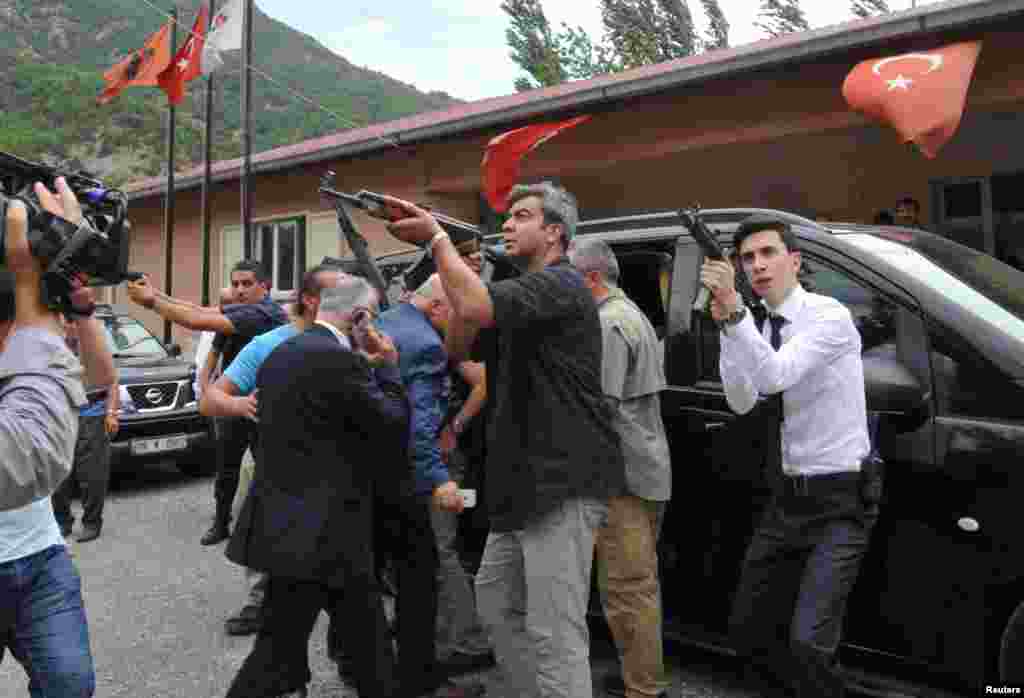 The vehicle belonging to the leader of Turkey's Republican People's Party, Kemal Kilicdaroglu (not seen), is guarded by security officers after an attack against his convoy in the northeastern city of Artvin. Kilicdaroglu was unharmed but one Turkish soldier was killed when Kurdish militants opened fire. (Reuters)