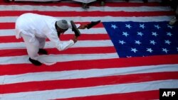 An activist of Jamaat-ud-Dawa, a religious charity founded by Hafiz Mohammad Saeed, beats a U.S. flag with his shoes during a protest rally in Karachi on April 6.