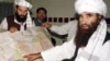 FILE: Jalaluddin Haqqani (R) points to a map of Afghanistan during a visit to Islamabad in October 2001.