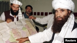 Jalaluddin Haqqani (right), the Taliban's minister for tribal affairs, points to a map of Afghanistan as son Nasiruddin, who was killed in Islamabad earlier this month, looks on during a 2001 visit to Islamabad.