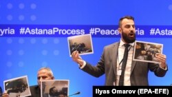 Member of Syrian armed opposition, former officer of the Syrian army, now an opposition, Yasir Abdur Rakhim (R) speaks as he demonstrates photo documents, during a press conference after the seventh round of talks on the Syrian conflict.