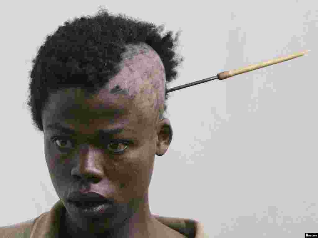 A young man with an arrow in his head arrives at hospital following ethnic clashes in the town of Nakuru in the Rift Valley area January 26, 2008. Kenyans in the Rift Valley town of Nakuru feared more violence on Saturday after a disputed election triggered pitched battles between ethnic gangs that killed at least a dozen people. REUTERS/Peter Andrews