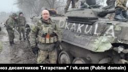 Руслан Файзутдинов ("Старик") стоит рядом с БМП "Дракула" незадолго до боя под Угледаром в феврале 2023 года. 