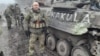 Руслан Файзутдинов ("Старик") стоит рядом с БМП "Дракула" незадолго до боя под Угледаром в феврале 2023 года. 