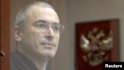 Former oil tycoon Mikhail Khodorkovsky stands behind a glass wall before the start of a court session in Moscow, in October 2010.