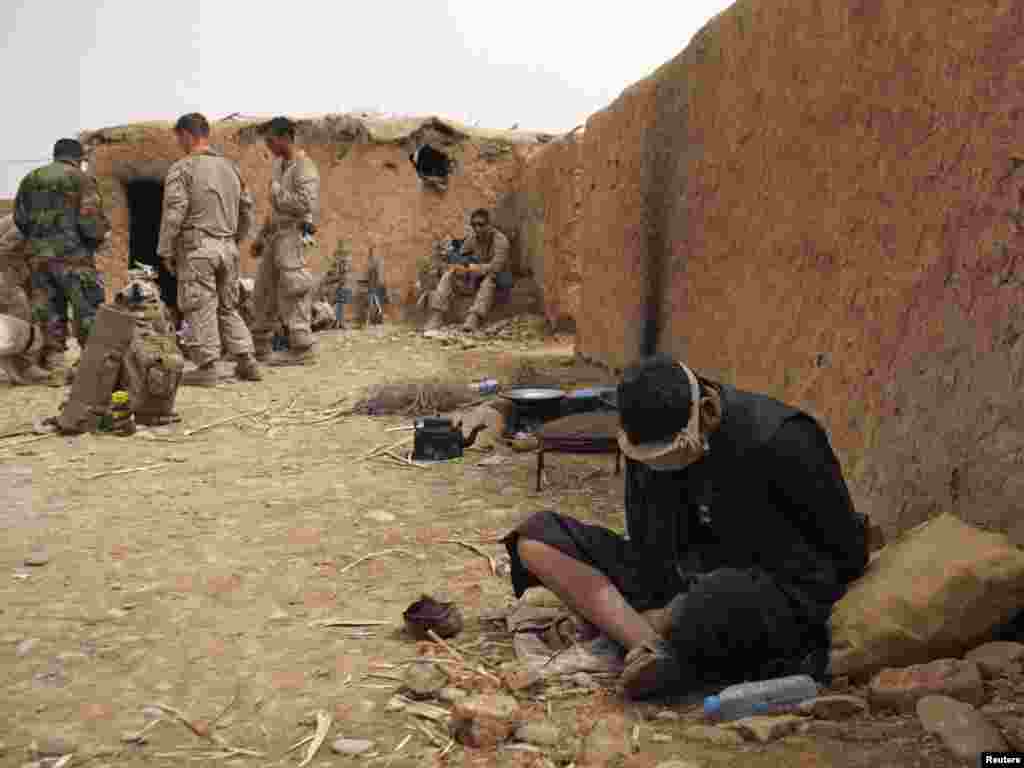 An Afghan man who is a possible suspect is detained in a compound held by U.S. Marines in Marjah district. - U.S. Marines continue operations in the Marjah district of the southern Helmand Province on March 29. Photo by Asmaa Waguih of Reuters