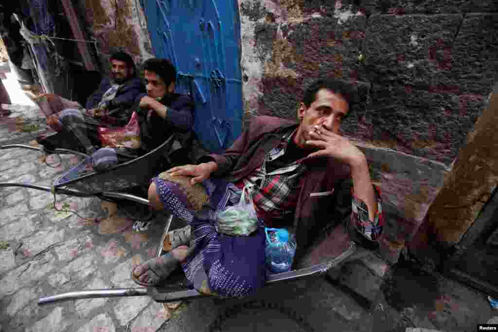 Burra duke pushuar e tymosur cigare, në një treg të vjetër në Sanaa, Jemen. &nbsp;(Reuters/Mohamed al-Sayaghi)