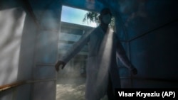 Një punëtor shëndetësor ecën në një tunel dezinfektimi jashtë një ambulance kushtuar pacientëve COVID -19 në Klinikën për Sëmundje Infektive gjatë pandemisë, 21 shtator 2020. 