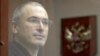 Former oil tycoon Mikhail Khodorkovsky stands behind a glass wall before the start of a court session in Moscow, in October 2010.