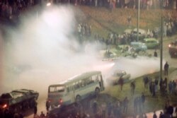 Радянські танки, у хмарі сльозогінного газу, прокочуються через барикаду із автомобілів перед вільнюськім телецентром. Литва, 13 січня 1991 року