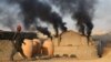 PAKISTAN -- A man stands near smoke billowing from a brick kiln in Karachi, December 14, 2018