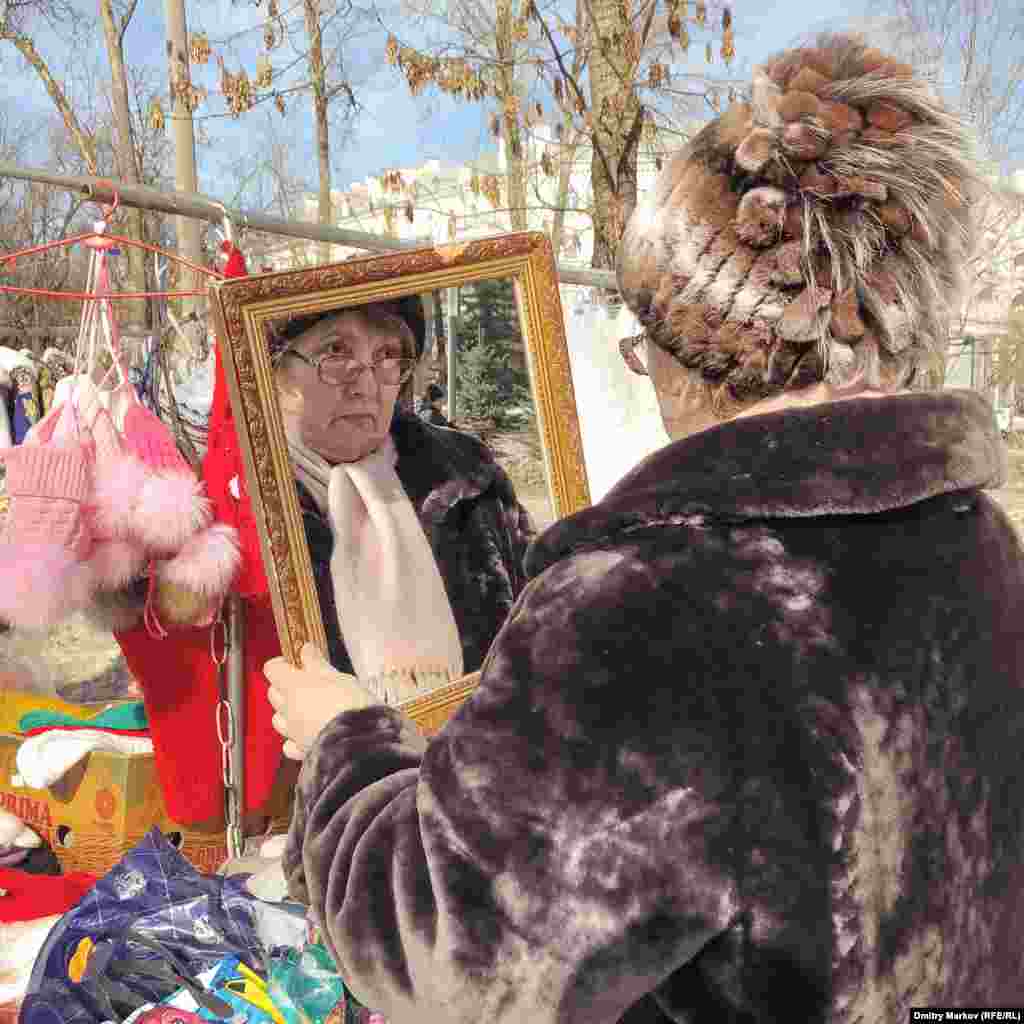 A customer tries on a hat at the fair.&nbsp;